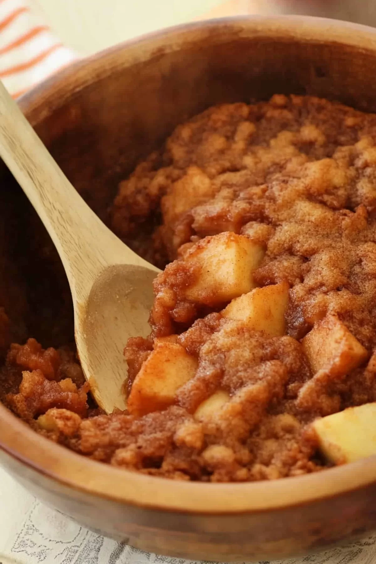 Freshly baked Apple Brown Betty with golden-brown crumb topping in a wooden bowl.