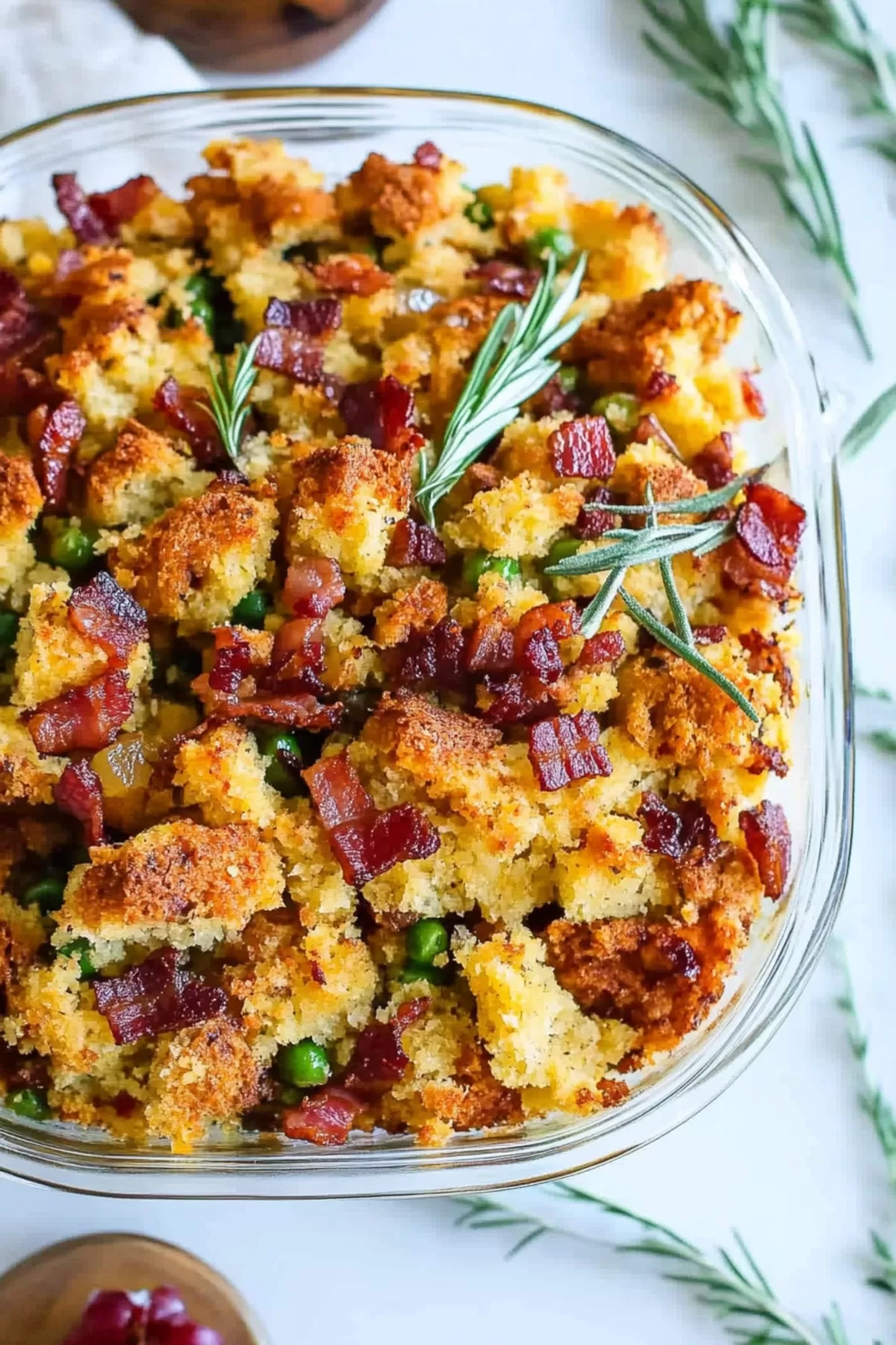 A baking dish filled with freshly baked stuffing, topped with crispy bacon and lightly browned edges.