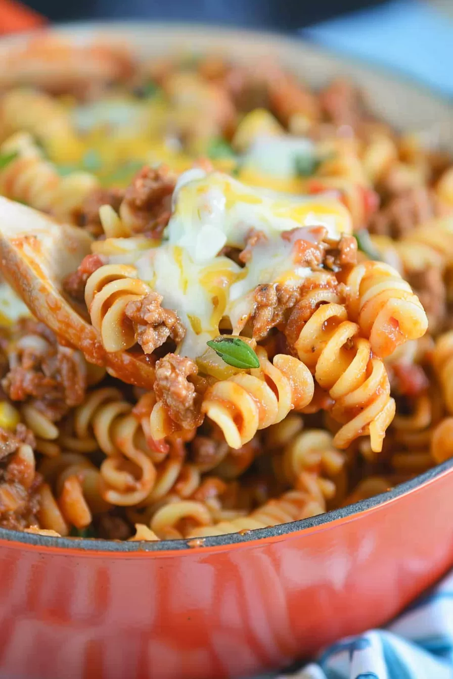 Close-up of Creamy Pasta with Taco Flavors: A bowl filled with pasta coated in a rich, cheesy sauce, topped with ground beef and garnished with fresh cilantro.