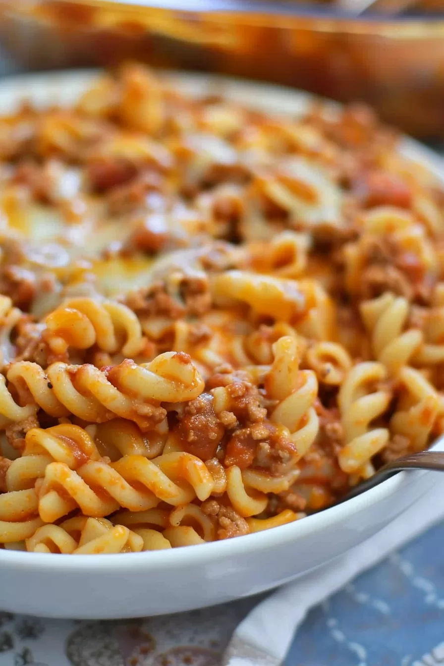 Baked Pasta with Cheese and Taco Seasoning: Hearty pasta covered in melted cheese and taco-seasoned beef, garnished with chopped cilantro for added freshness.