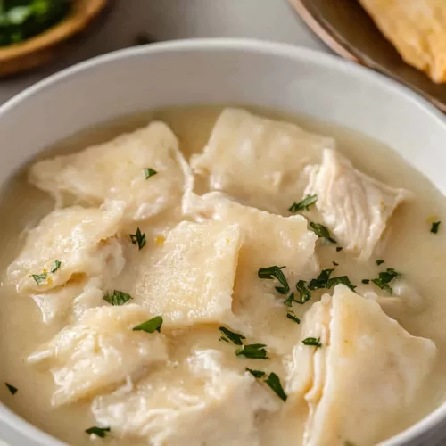 A serving of dumplings and juicy chicken, topped with a sprinkle of black pepper.