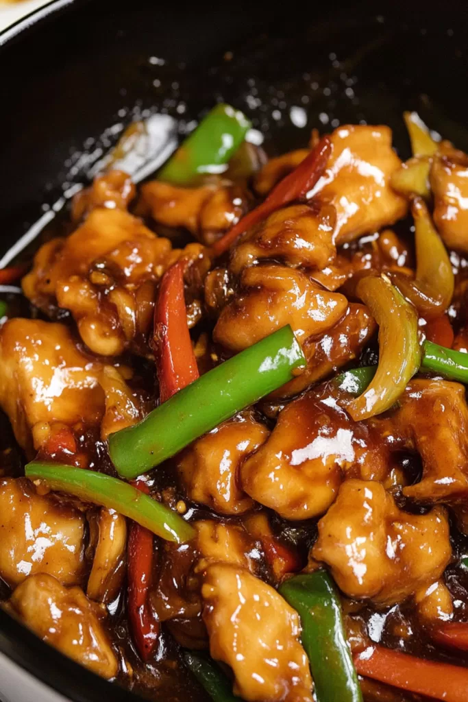 Juicy stir-fried chicken pieces in a glossy, savory sauce with vibrant vegetables.