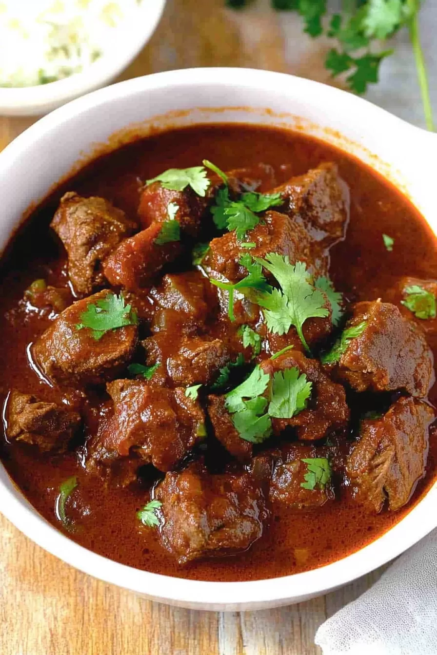 Rich, savory stew with tender beef pieces and a vibrant red sauce.