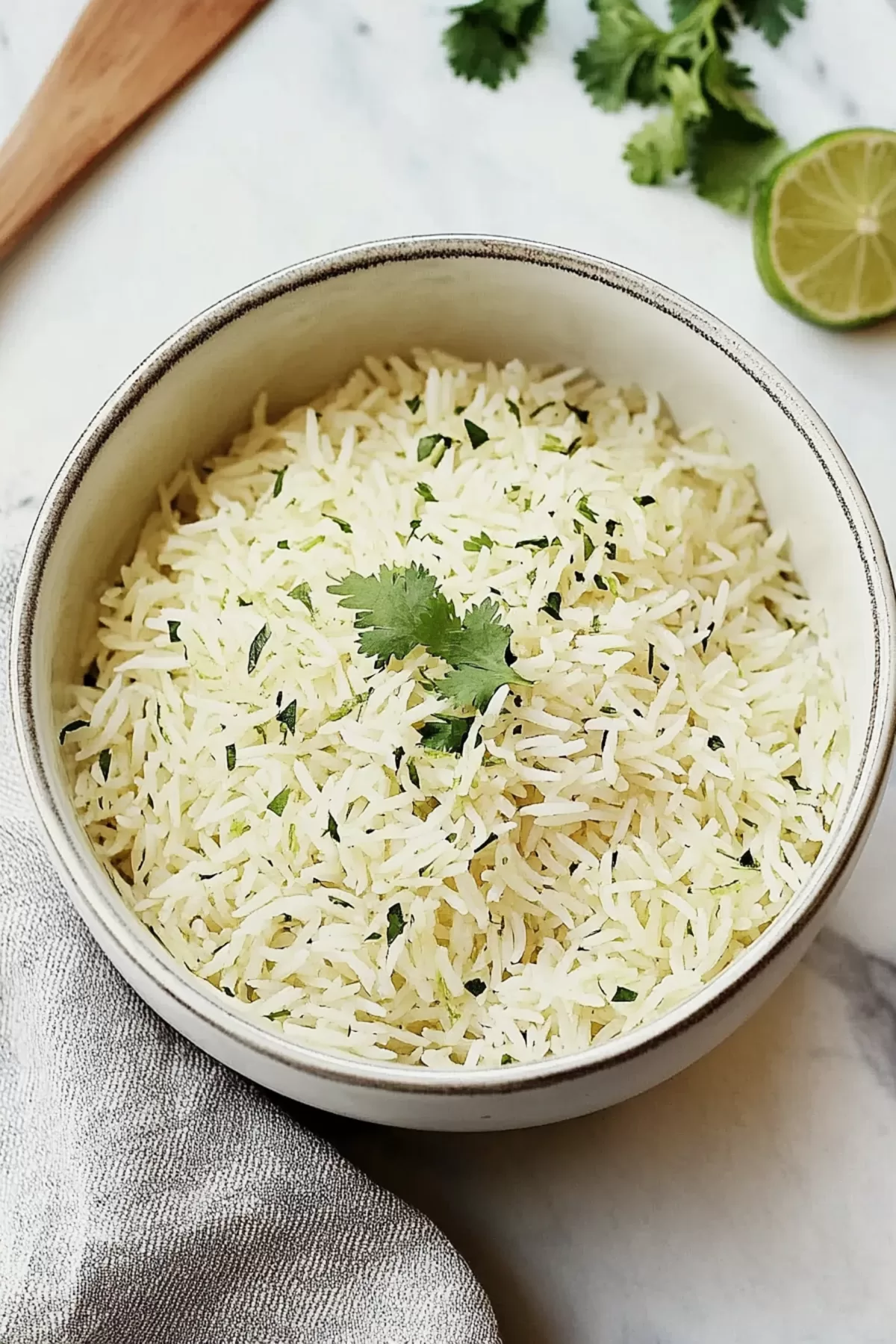 Freshly cooked rice with lime zest and cilantro, served in a rustic ceramic bowl.