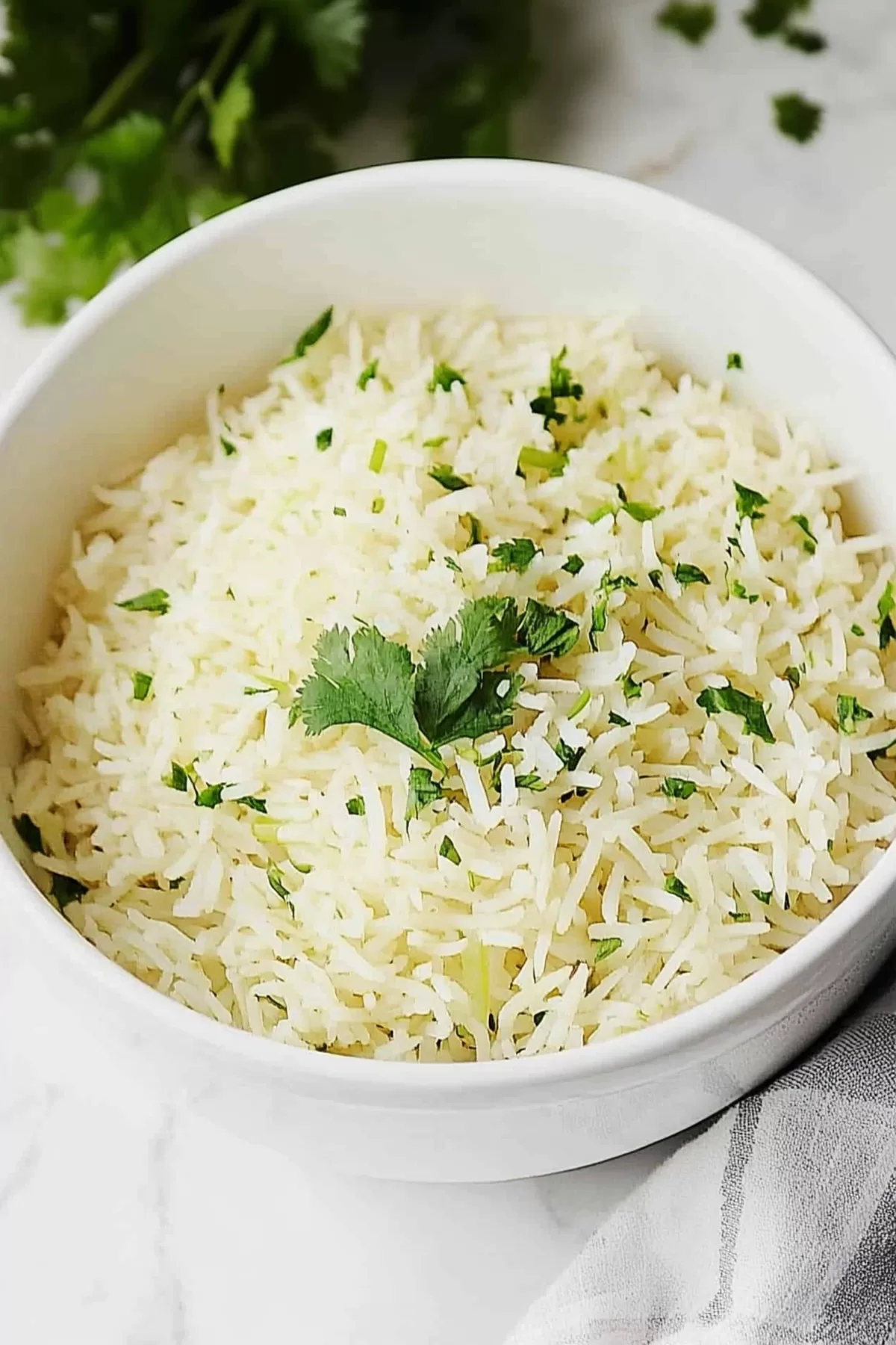 Close-up of steaming white rice with vibrant green cilantro mixed throughout.