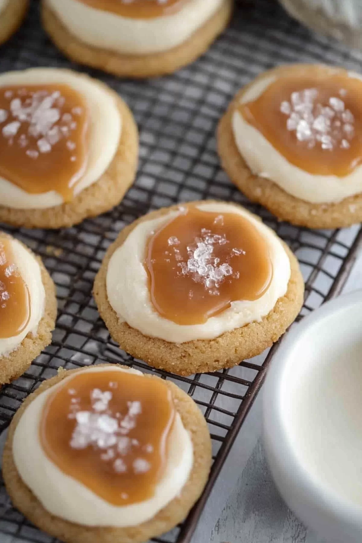 A tray of soft cookies with decorative caramel drizzle and a touch of sea salt.