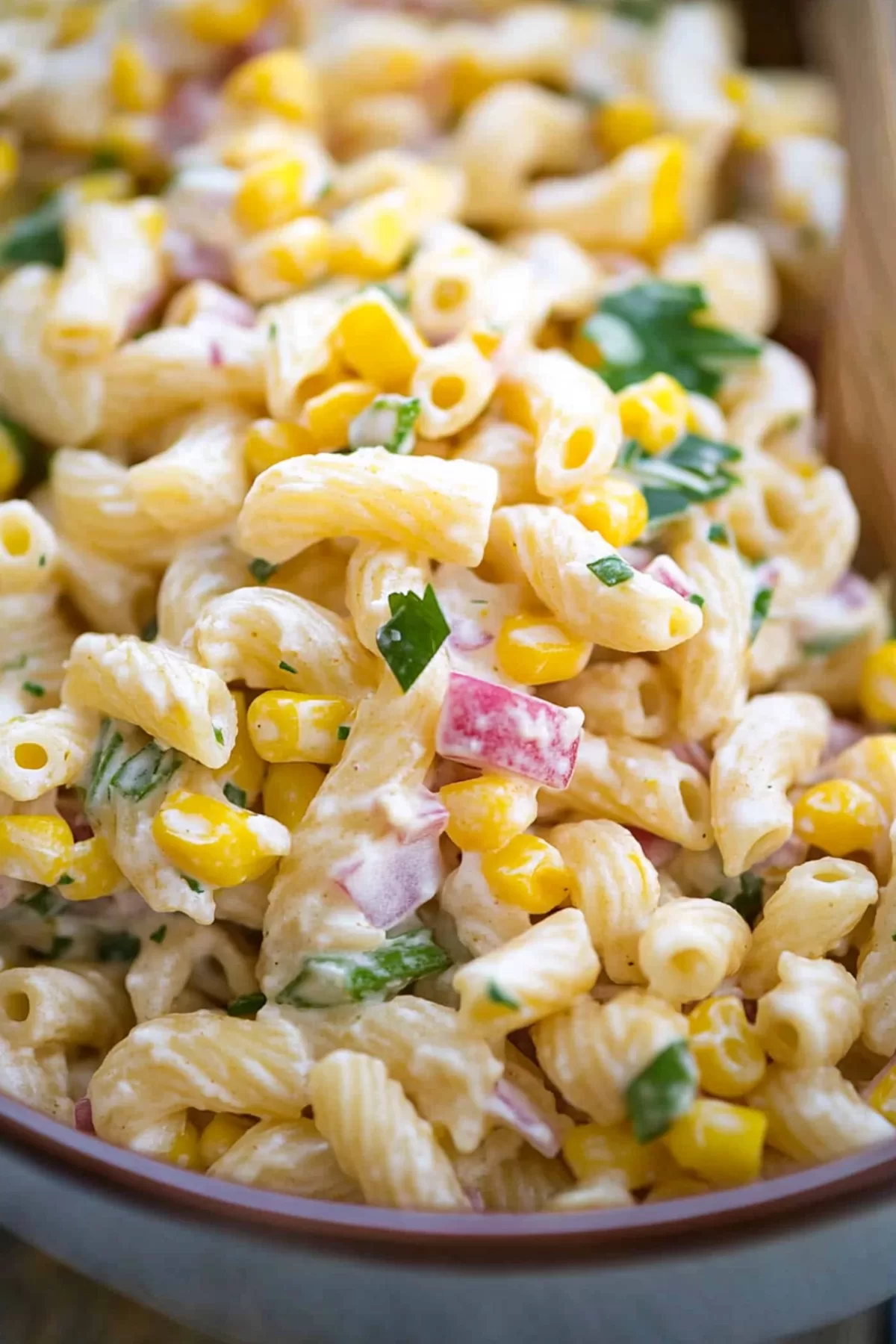 A plate of chilled pasta tossed with crisp veggies and a zesty sauce.