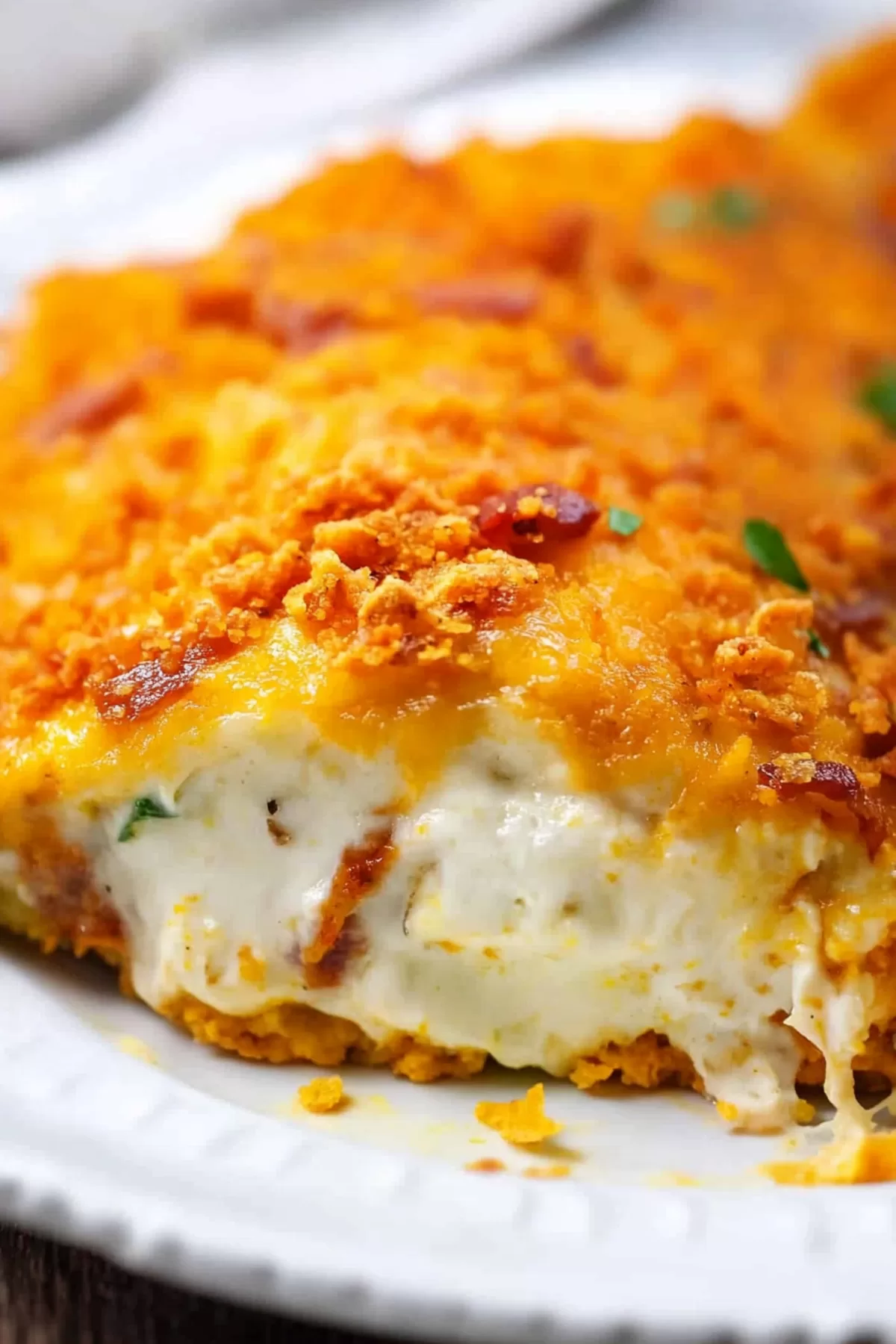 Close-up of golden, breaded chicken with a creamy, cheesy filling spilling out.