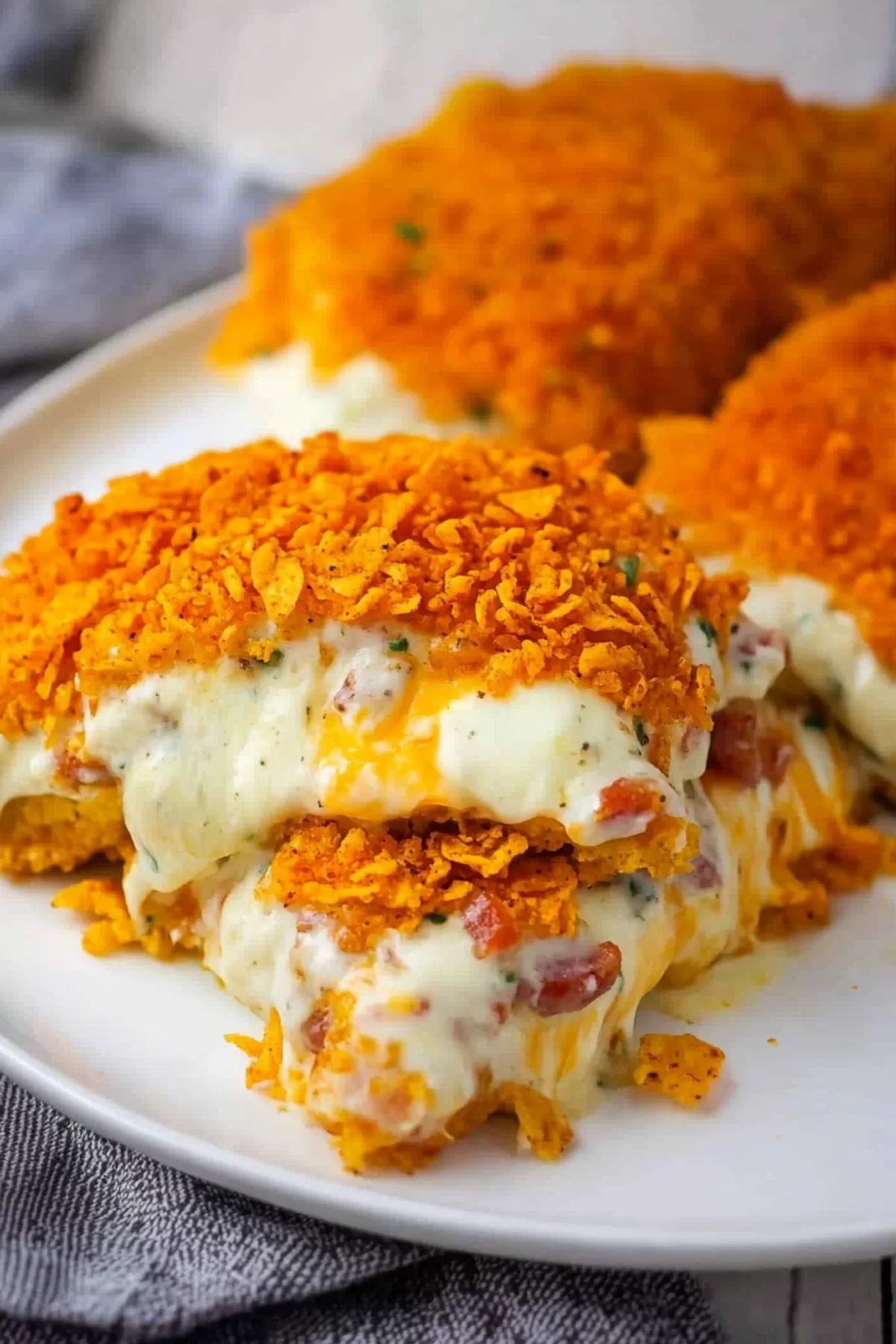 Sliced stuffed chicken revealing a creamy cheese and bacon center, wrapped in a crunchy crust.