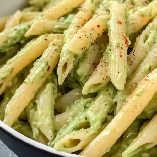 A serving of pasta with a velvety avocado sauce, topped with cherry tomatoes for a pop of color.