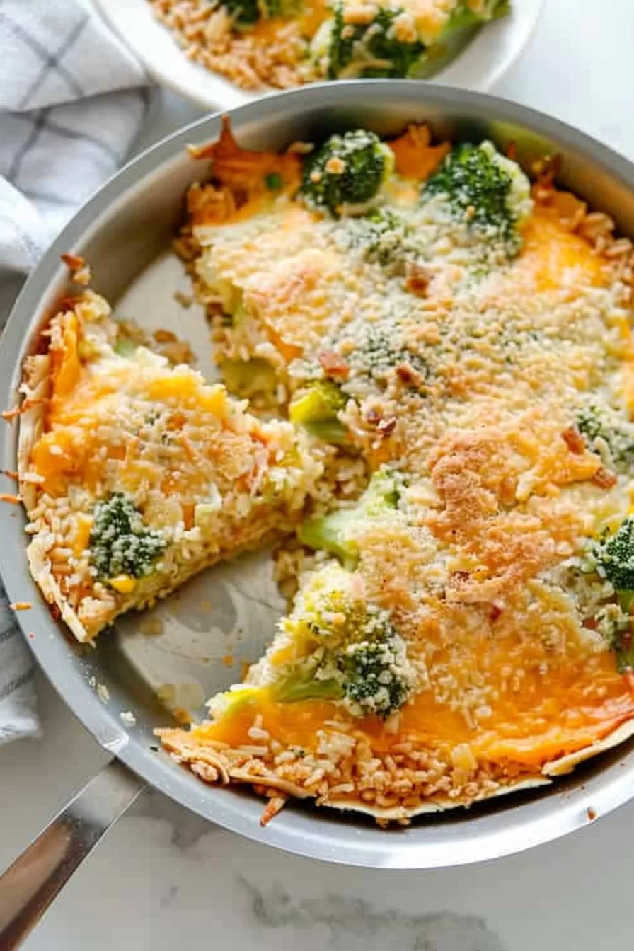 Overhead view of the broccoli rice pie, showing melted cheese on top and pieces of broccoli.