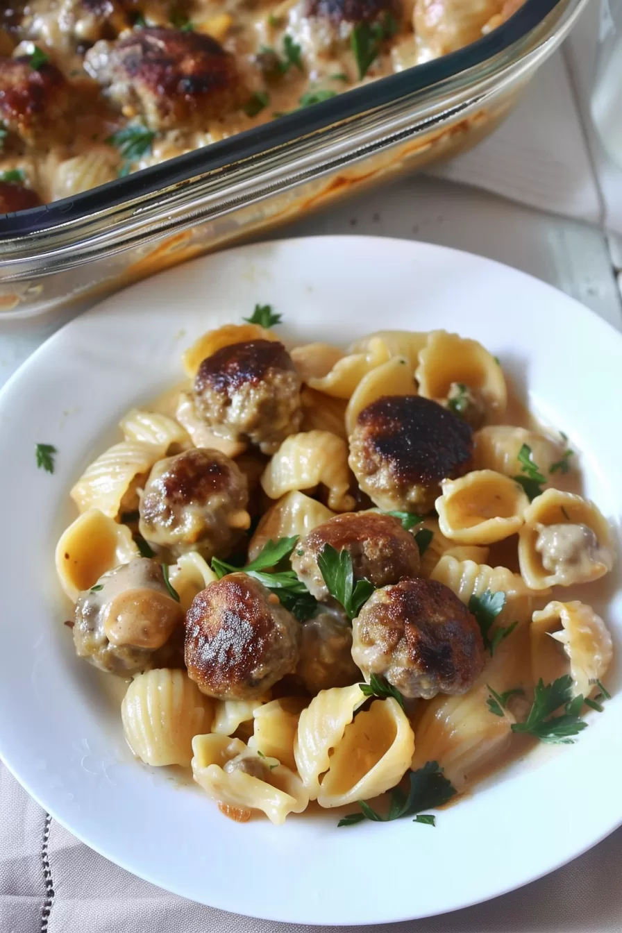 Golden, bubbling casserole dish with creamy pasta and meatballs, ready to serve.