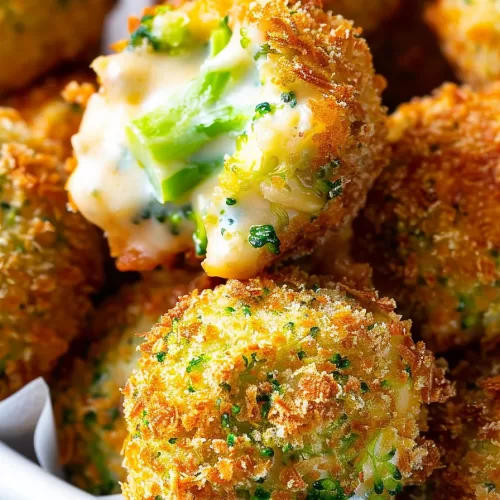 Close-up of a crispy cheese ball, showing a soft, cheesy center with broccoli.