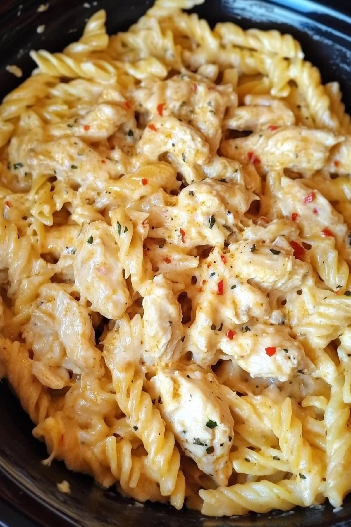 A close-up of creamy garlic parmesan pasta with tender chicken, garnished with fresh parsley.