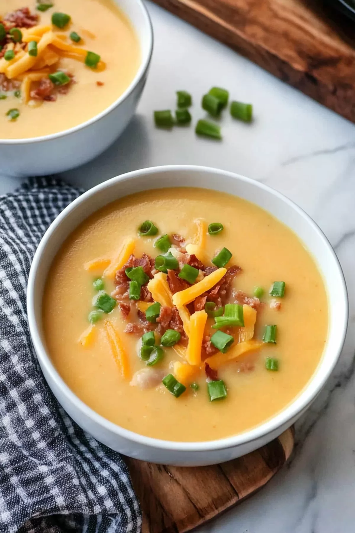 A comforting bowl of potato soup showcasing rich texture and colorful toppings like bacon and cheese.