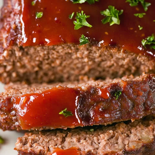 A classic meatloaf with a golden crust, topped with herbs and a flavorful tomato-based glaze.