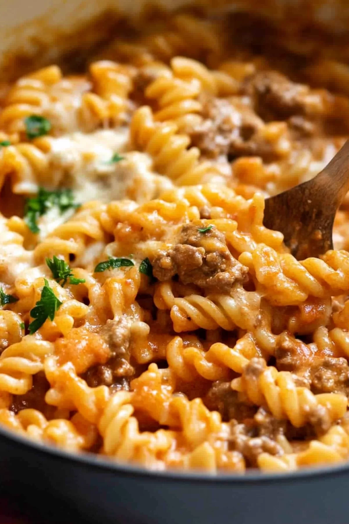 A rich and creamy pasta dish with minced beef and a vibrant tomato-based sauce, garnished with parsley and grated cheese.