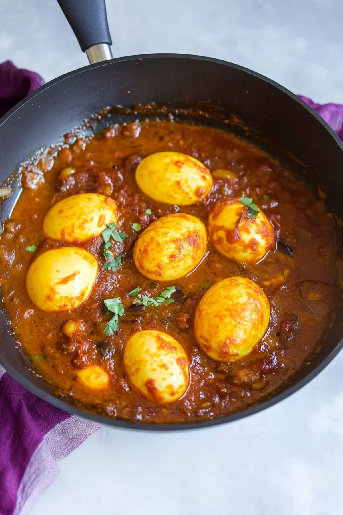 Aromatic spiced curry with eggs served alongside naan bread for a comforting meal.