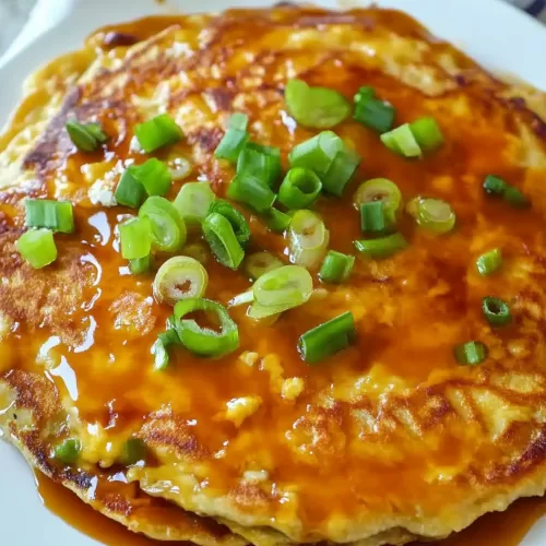 A perfectly cooked Egg Foo Young pancake with crispy edges and a generous drizzle of brown sauce, ready to serve.