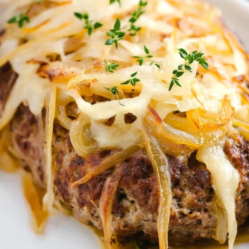 A hearty serving of baked meatloaf with visible layers of onion and cheese.