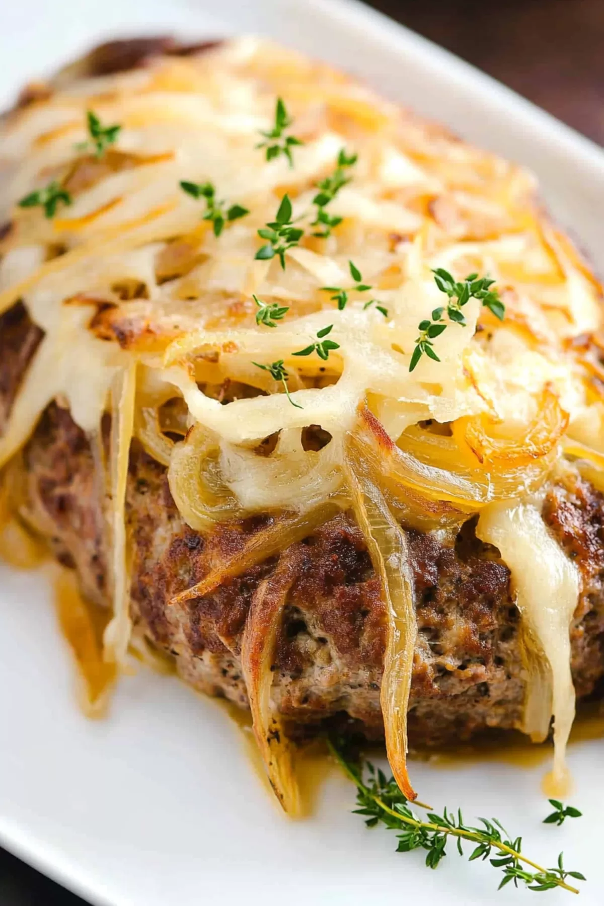 A hearty serving of baked meatloaf with visible layers of onion and cheese.