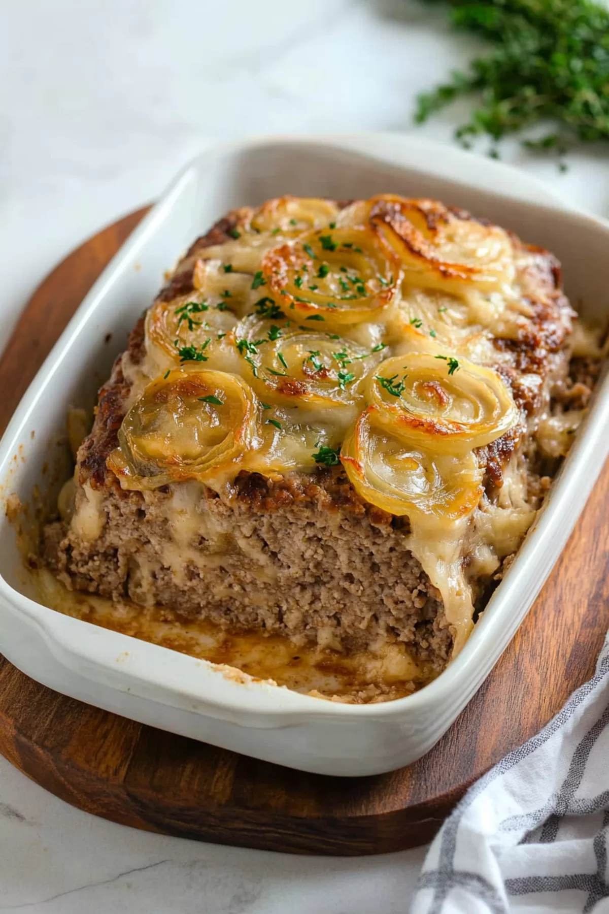 Sliced meatloaf revealing a tender, flavorful interior, topped with caramelized onions.