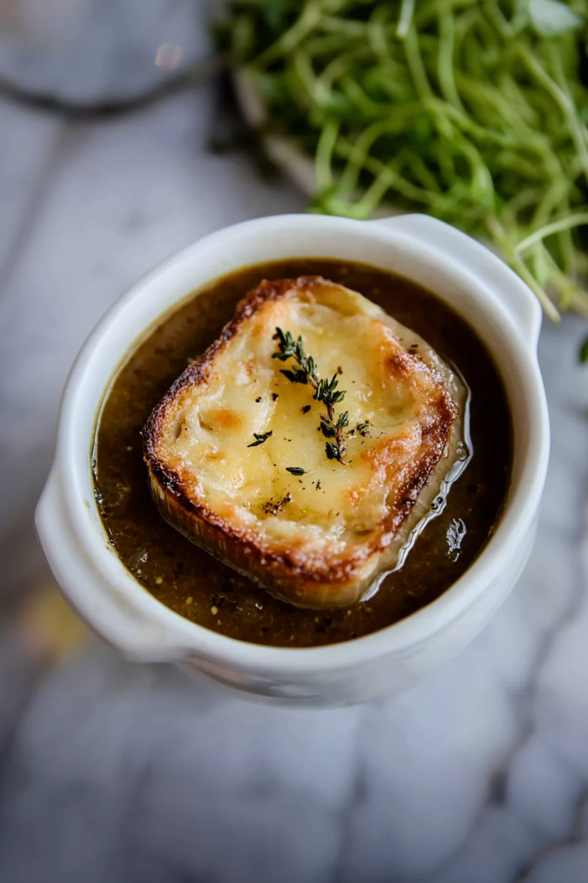 A comforting dish with layers of melted cheese, toasted bread, and a savory broth.