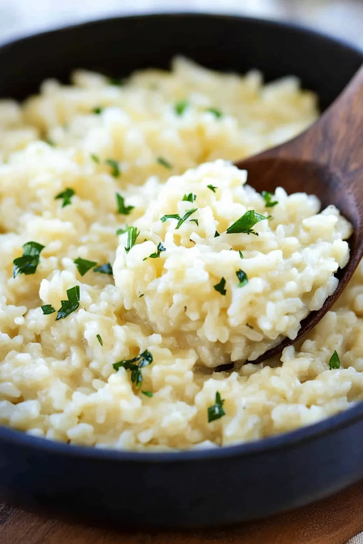 A wooden spoon lifting a portion of creamy risotto, highlighting its rich and cheesy texture.