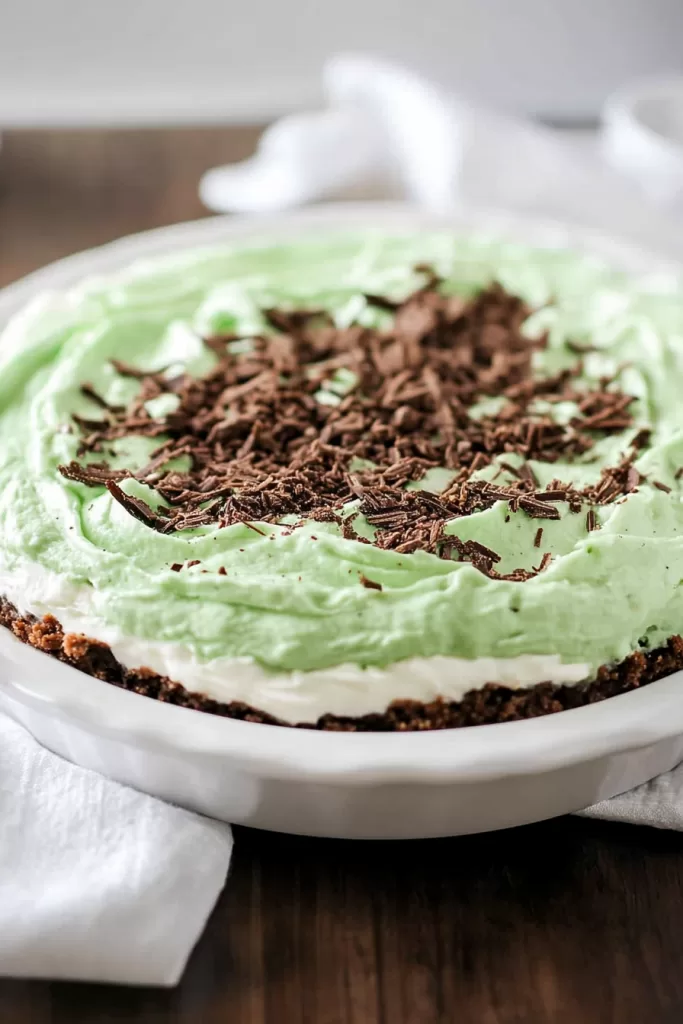 A creamy, minty pie with a chocolate crust, topped with chocolate shavings.