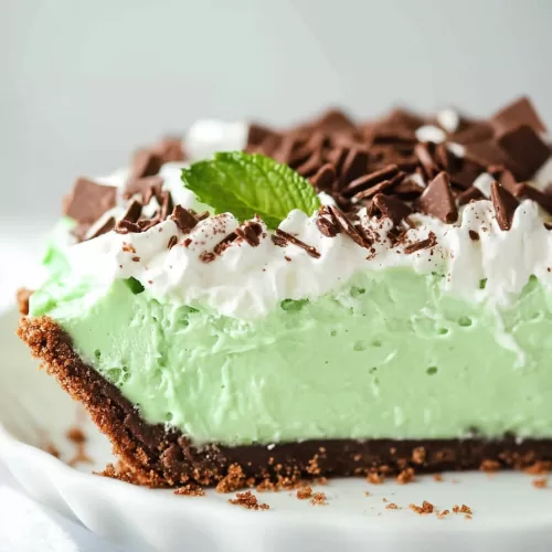 Whipped mint pudding filling in a pie crust, garnished with a sprinkle of chocolate.