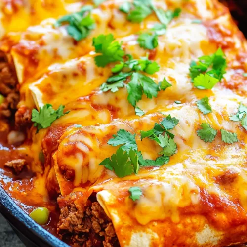 Close-up of a smothered burrito filled with seasoned ground beef and topped with melted cheese.