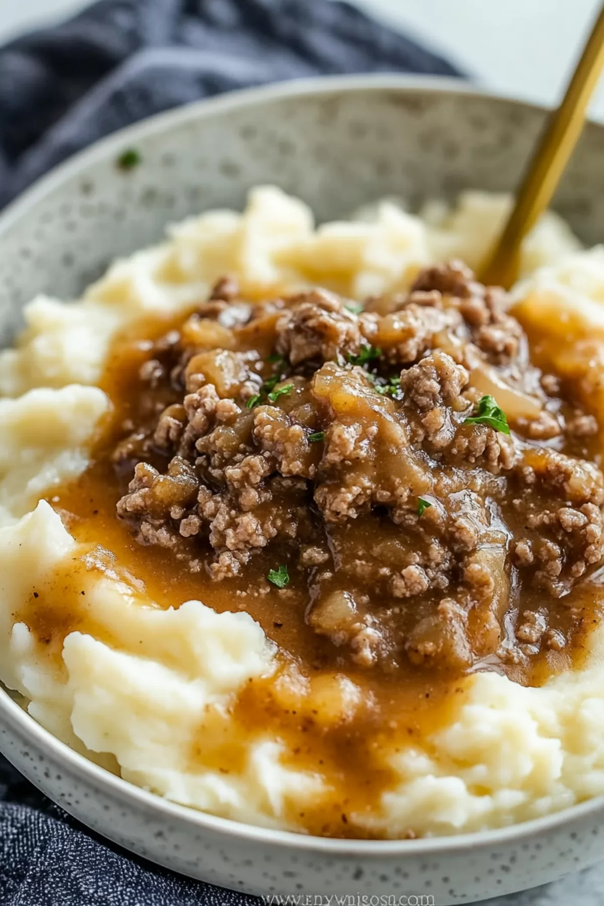 Hearty plate of mashed potatoes served with a generous portion of ground beef in gravy.