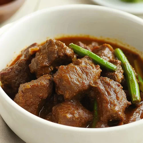 Warm and hearty beef curry with a vibrant red-brown sauce, perfect for comfort food.