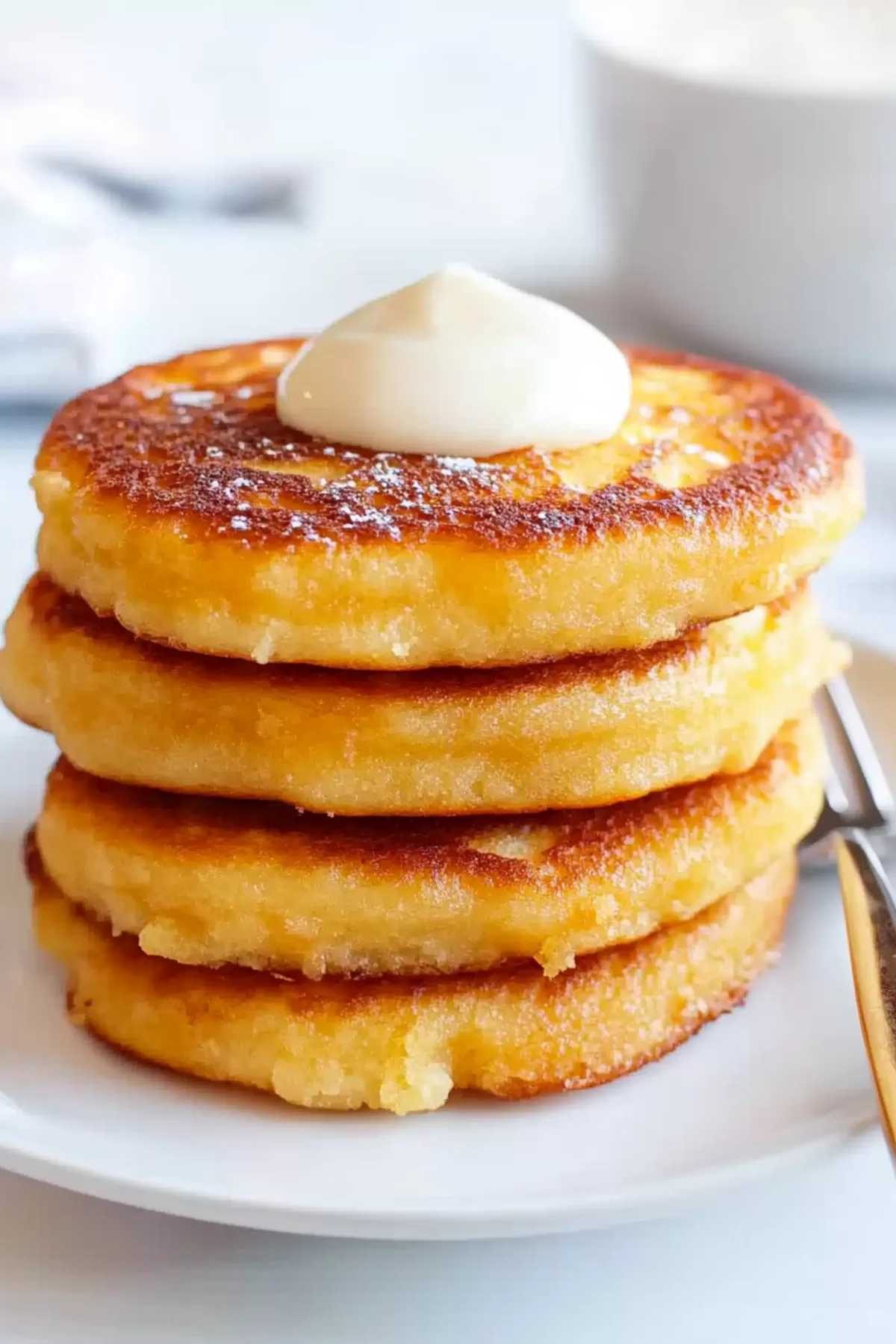 A close-up view of thick, golden pancakes highlighting their crispy exterior and fluffy interior.