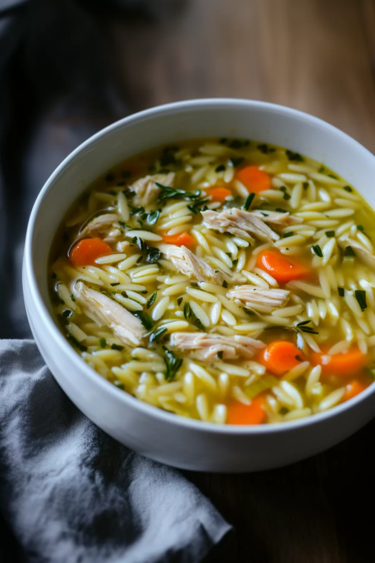 Bright and inviting soup served in a ceramic bowl, showcasing fresh greens and hearty orzo pasta.