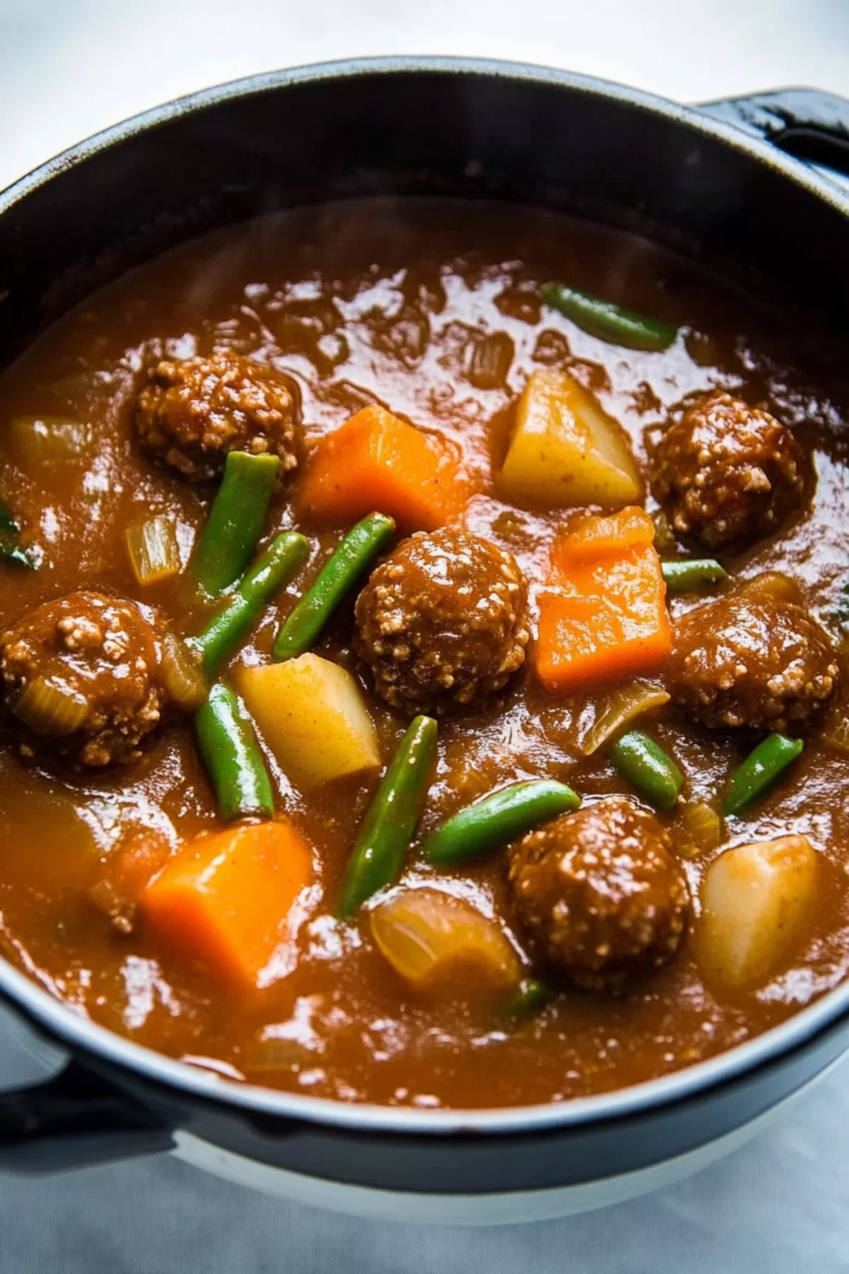 A close-up shot of flavorful meatballs nestled in a savory sauce.