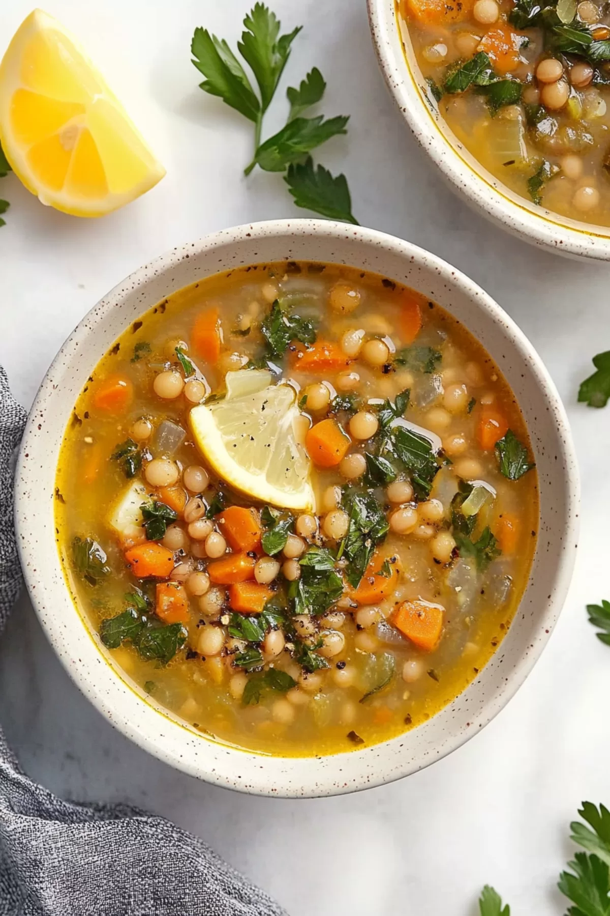 An overhead shot of Mediterranean lentil soup, featuring a mix of fresh greens, lentils, and flavorful broth.