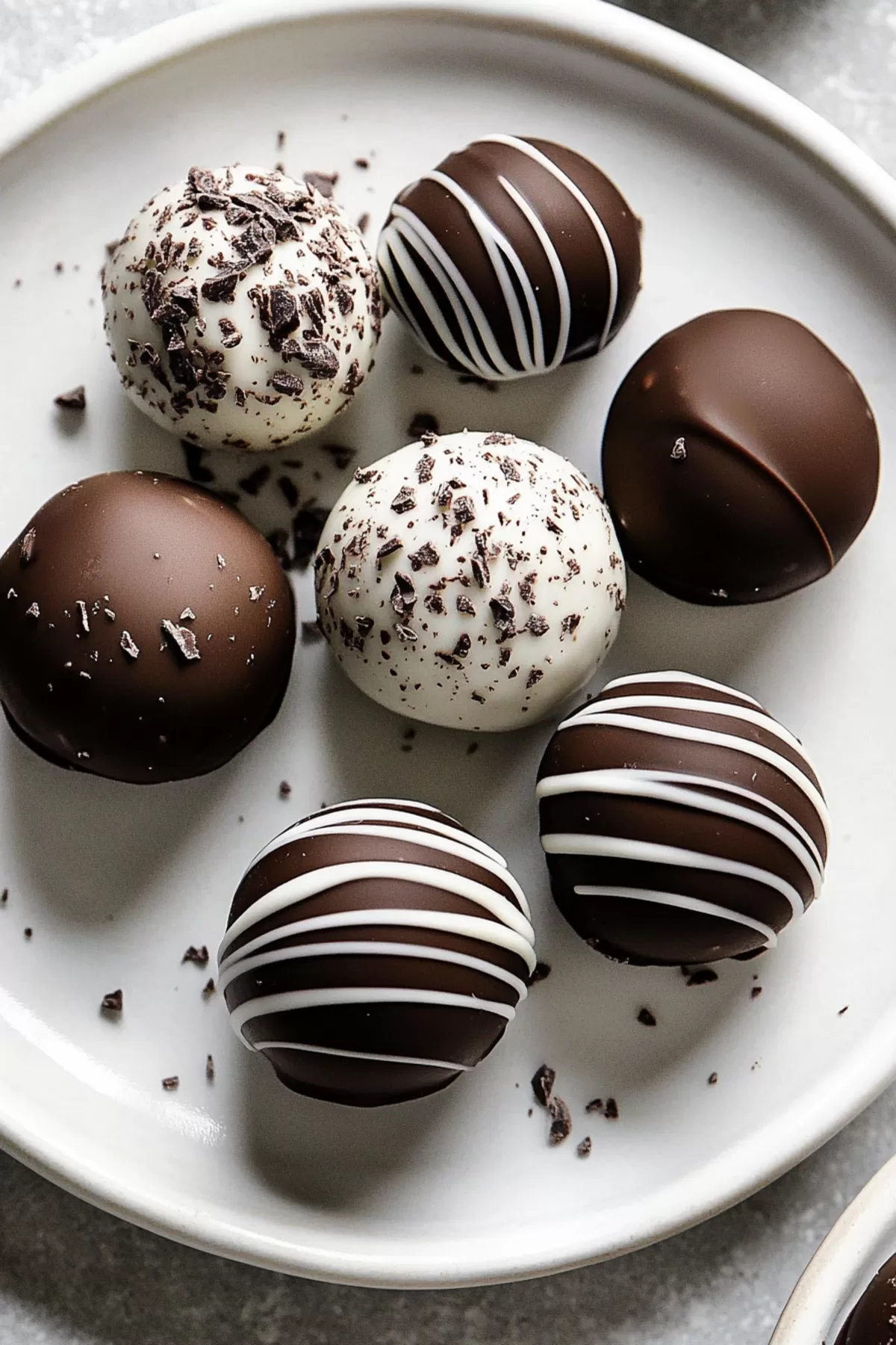 Chocolate-coated truffle with a smooth, creamy center on a dessert platter.