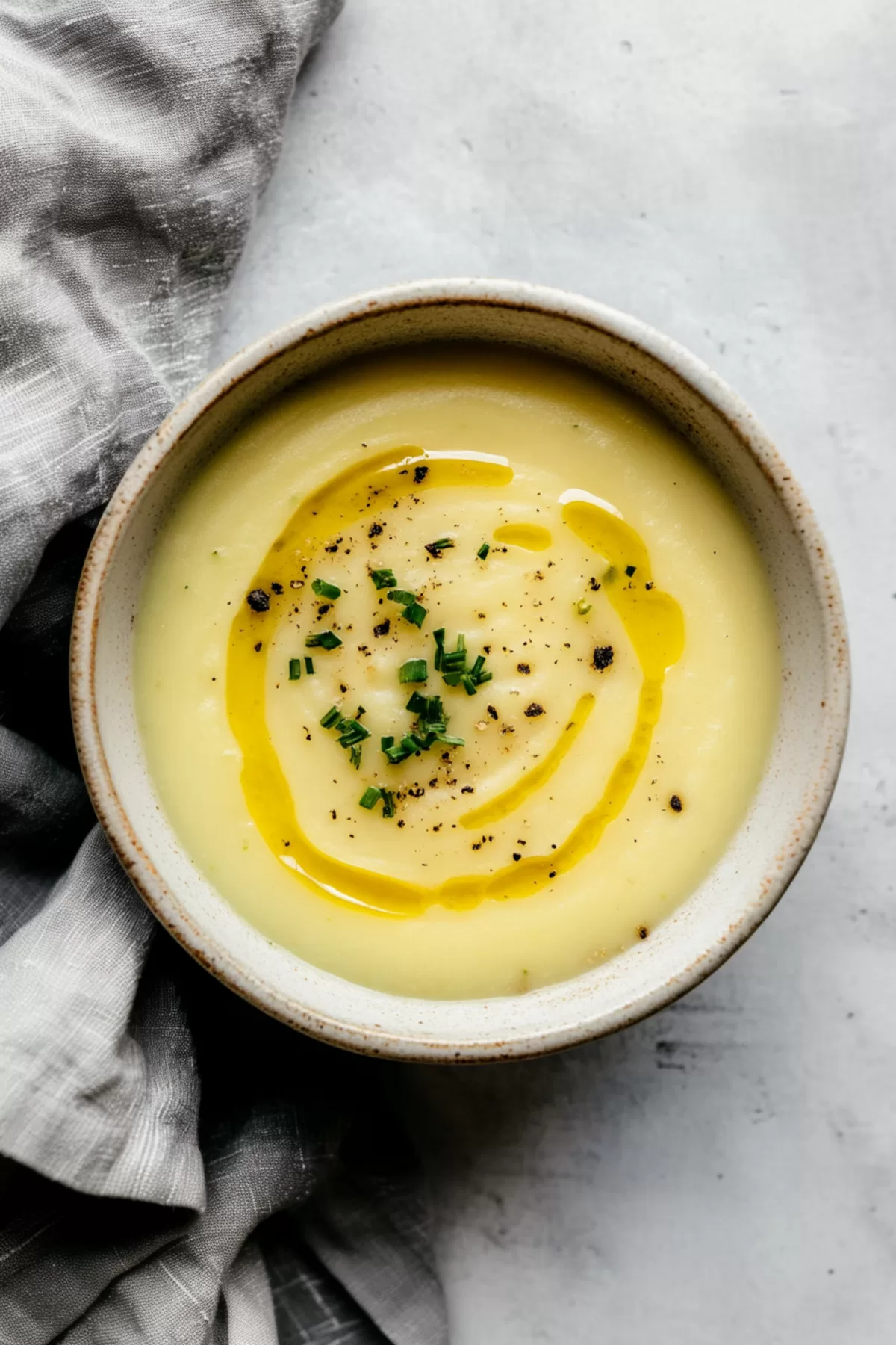 A rich and creamy soup showcasing its vibrant garnish of fresh herbs.