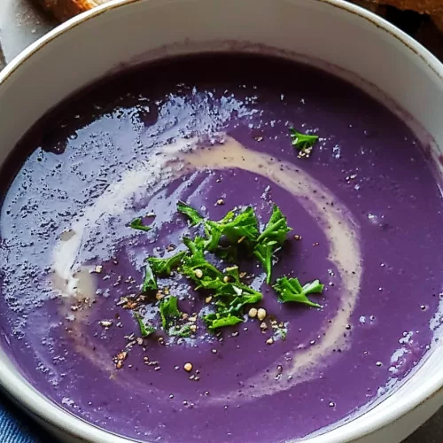 Close-up of a steaming bowl of soup with rich purple hues and hearty vegetables.