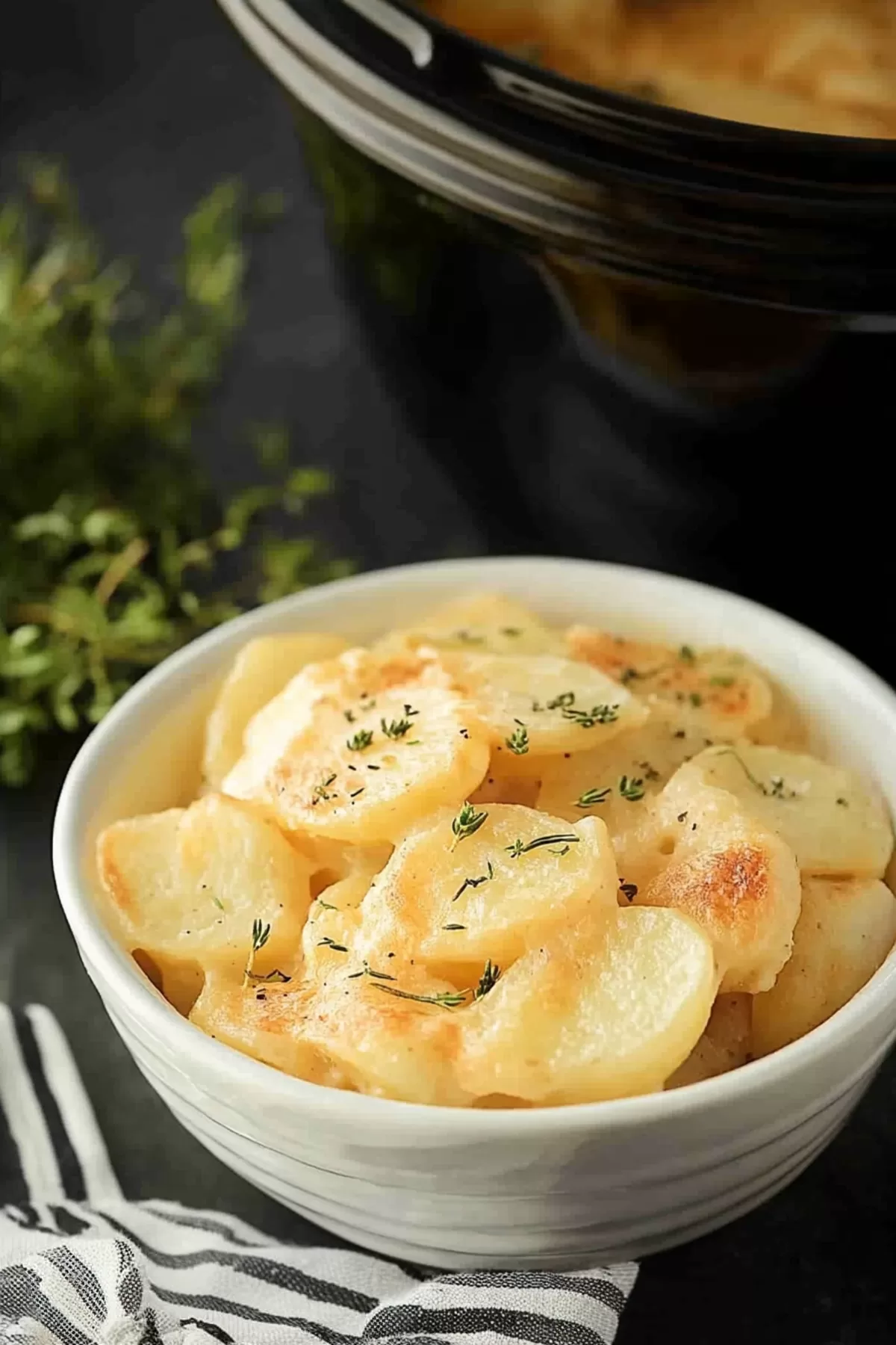 Warm, cheesy potato casserole garnished with fresh herbs, perfect for any gathering.