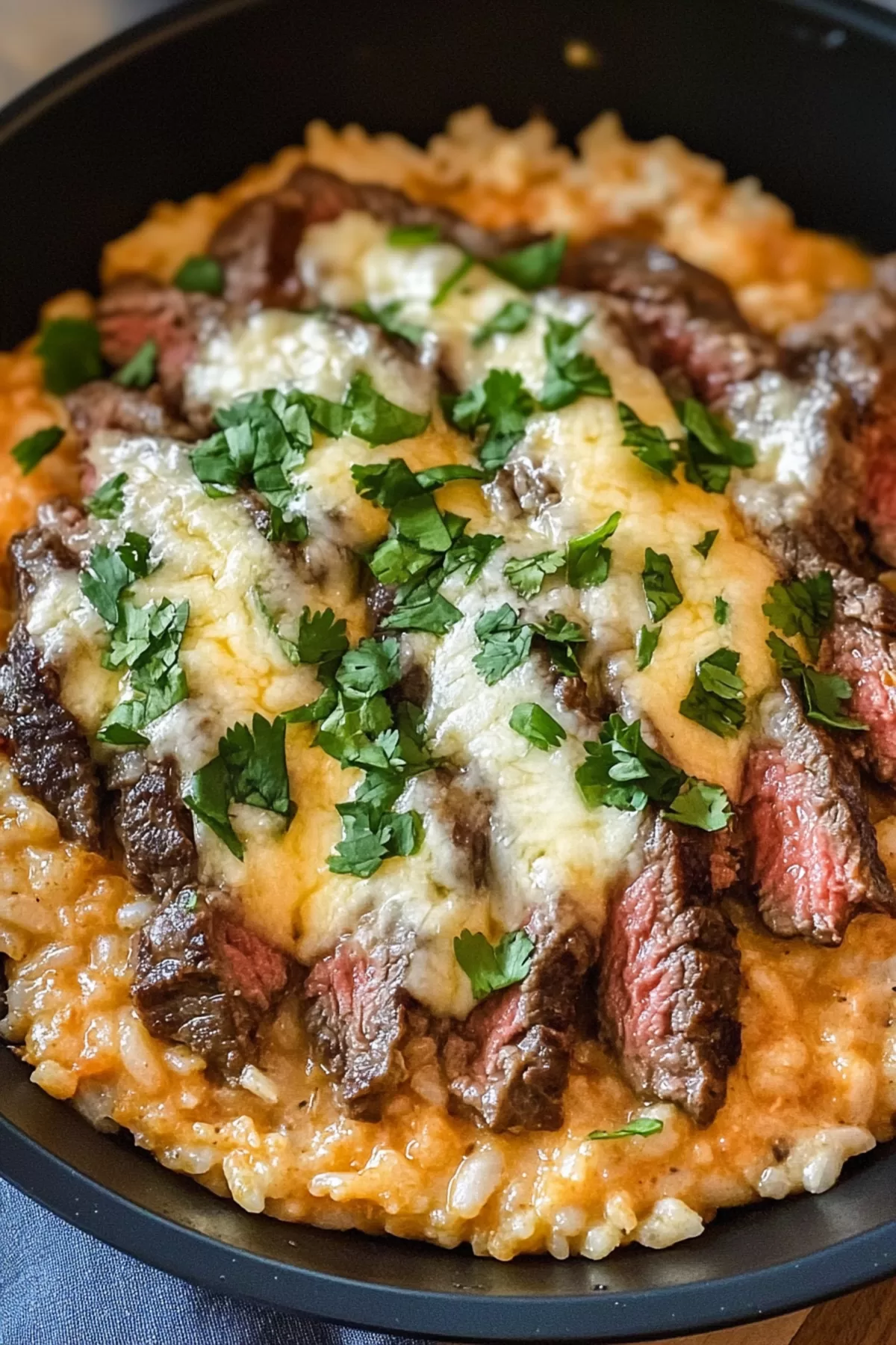 A cheesy rice with chunks of steak and melted queso.