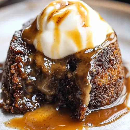 Close-up of a moist dessert with a glossy, dark sauce coating.