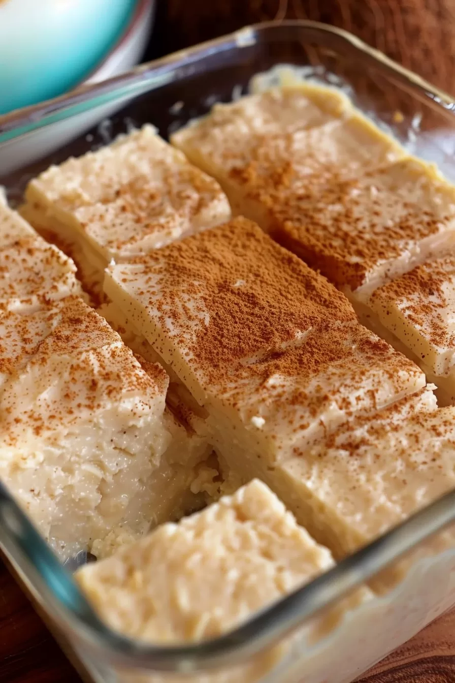 Traditional coconut dessert squares with a creamy consistency and golden cinnamon topping.