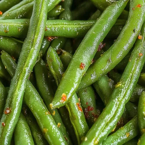 Perfectly crisp and seasoned green beans piled together, highlighting their texture and rich color.