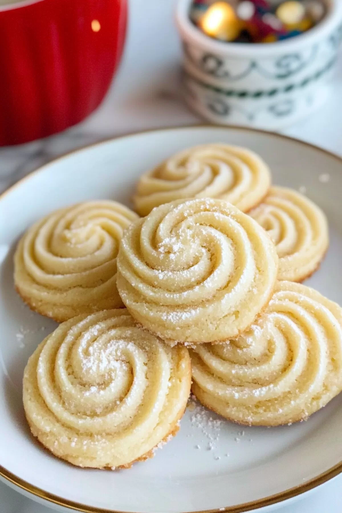 A tray filled with freshly baked butter cookies, surrounded by holiday-themed decor.