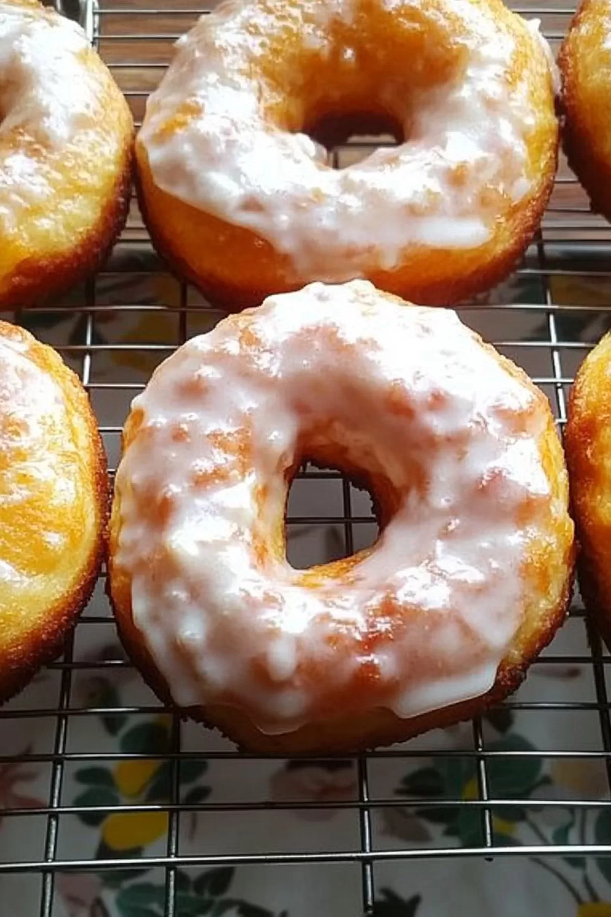 Freshly made donuts cooling on a wire rack, ready to enjoy.