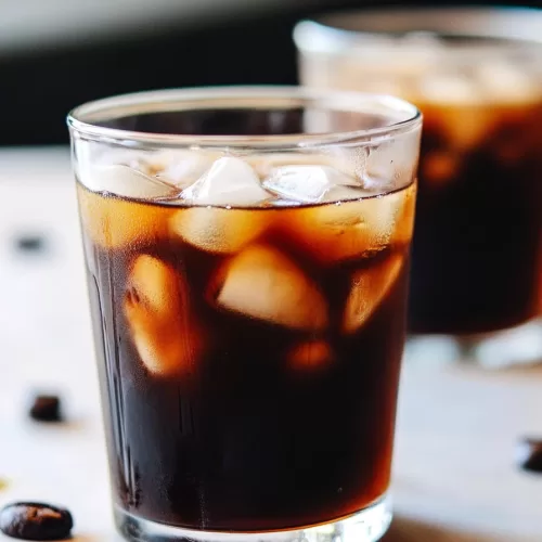 A single glass filled with iced coffee, showcasing the rich color and icy texture.