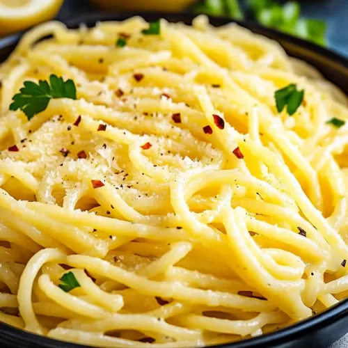 Golden pasta noodles glistening in a tangy lemon butter sauce with hints of fresh herbs.