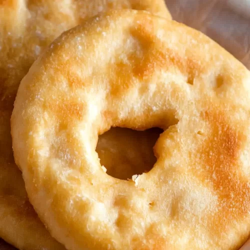 Freshly fried bread with a fluffy interior, arranged on a decorative cloth.